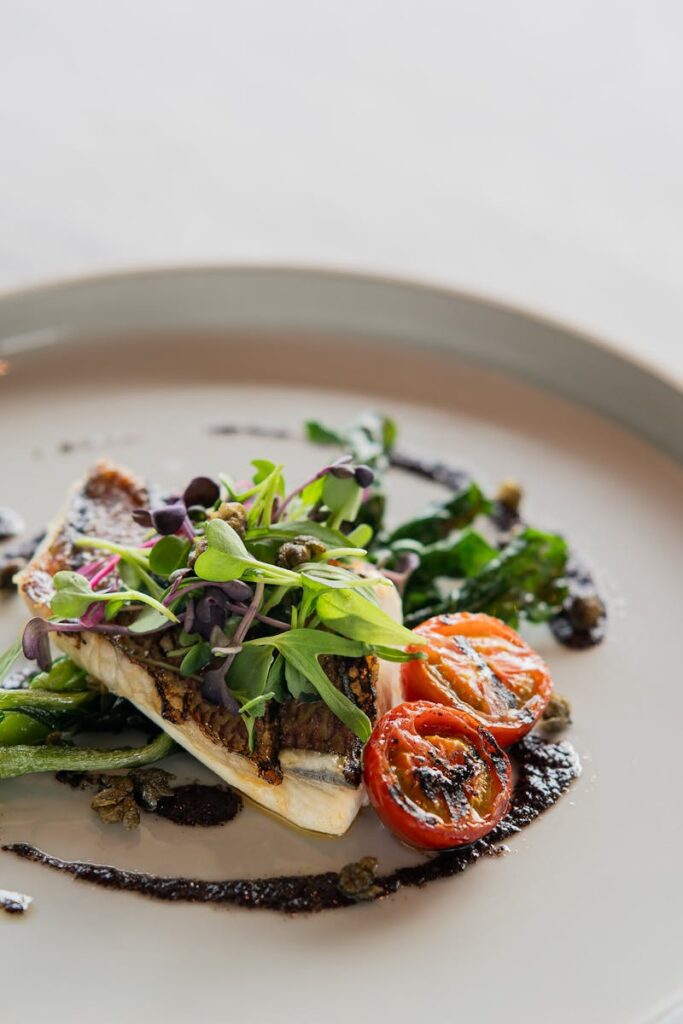 A beautifully plated gourmet dish with grilled vegetables and microgreens in a Tokyo restaurant.